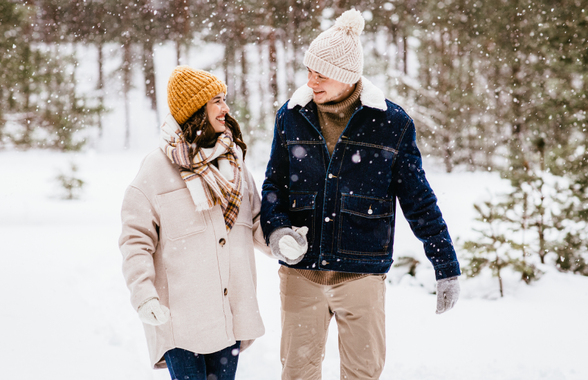 couple walking in the snowing forest 