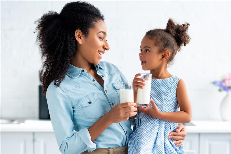 Mother and daughter holding a glass of milk in their hand